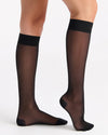 Black sheer stockings worn by a person on a white background