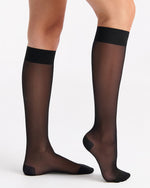Black sheer stockings worn by a person on a white background