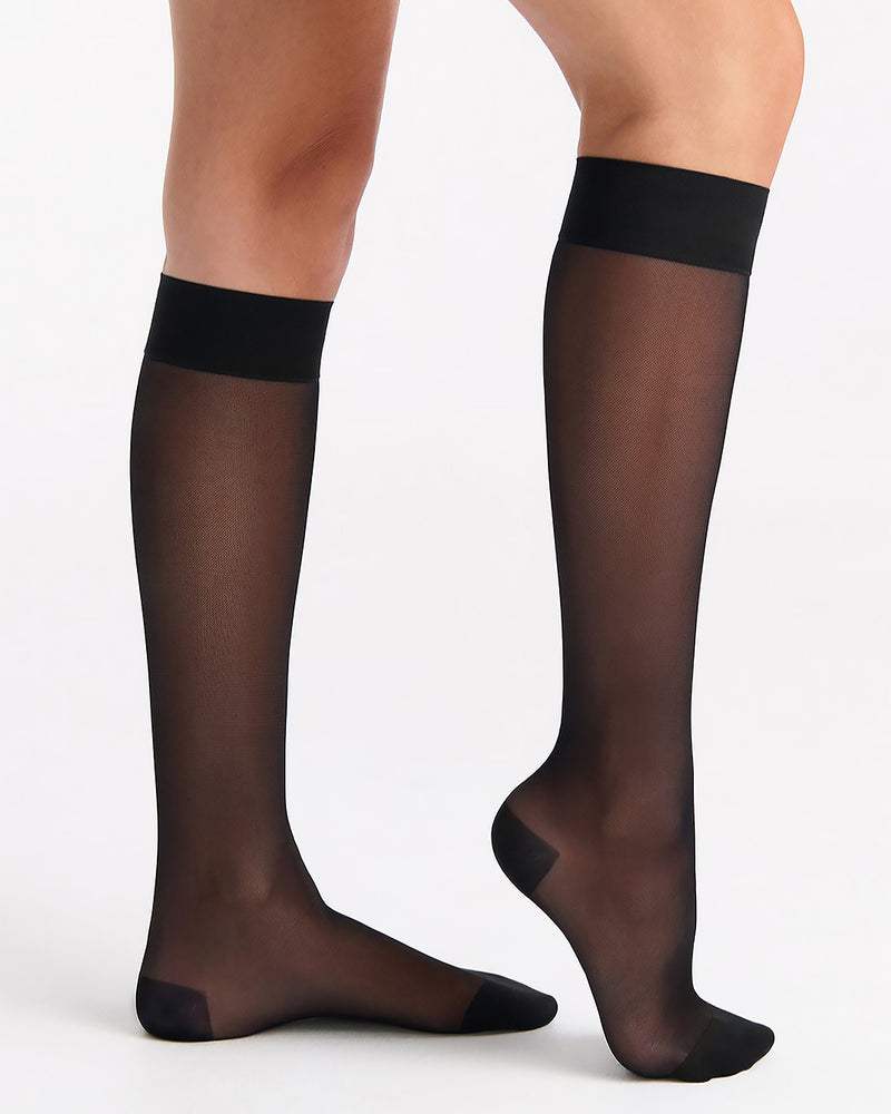 Black sheer stockings worn by a person on a white background